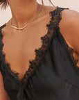 V-neck satin cami: Close-up of the delicate black lace trim detailing on the Charli Solange top neckline.