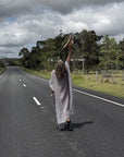 Person in a long estilo emporio maxi dress standing on a road with a cloudy sky