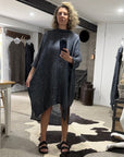 Woman taking a mirror selfie wearing ala bottega di brunella linen dress in a clothing store.