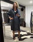 Woman taking a mirror selfie wearing a la bottega di brunella linen dress in a room with a large mirror.