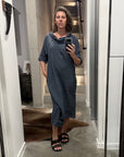 Person taking a mirror selfie in a room with a large floor-to-ceiling mirror wearing la bottega di brunella linen dress made in italy