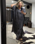 Person wearing a long striped la bottega di brunealla navy linen dress in a room with a mirror.