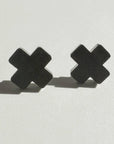 Mingled Black Cross Stud Earrings - Small Cross Earrings, Minimalist worn by model in natural setting LUXAMORE