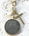 Pre Order Chunky coin necklace cross matte gold jewelry worn by model in natural setting LUXAMORE