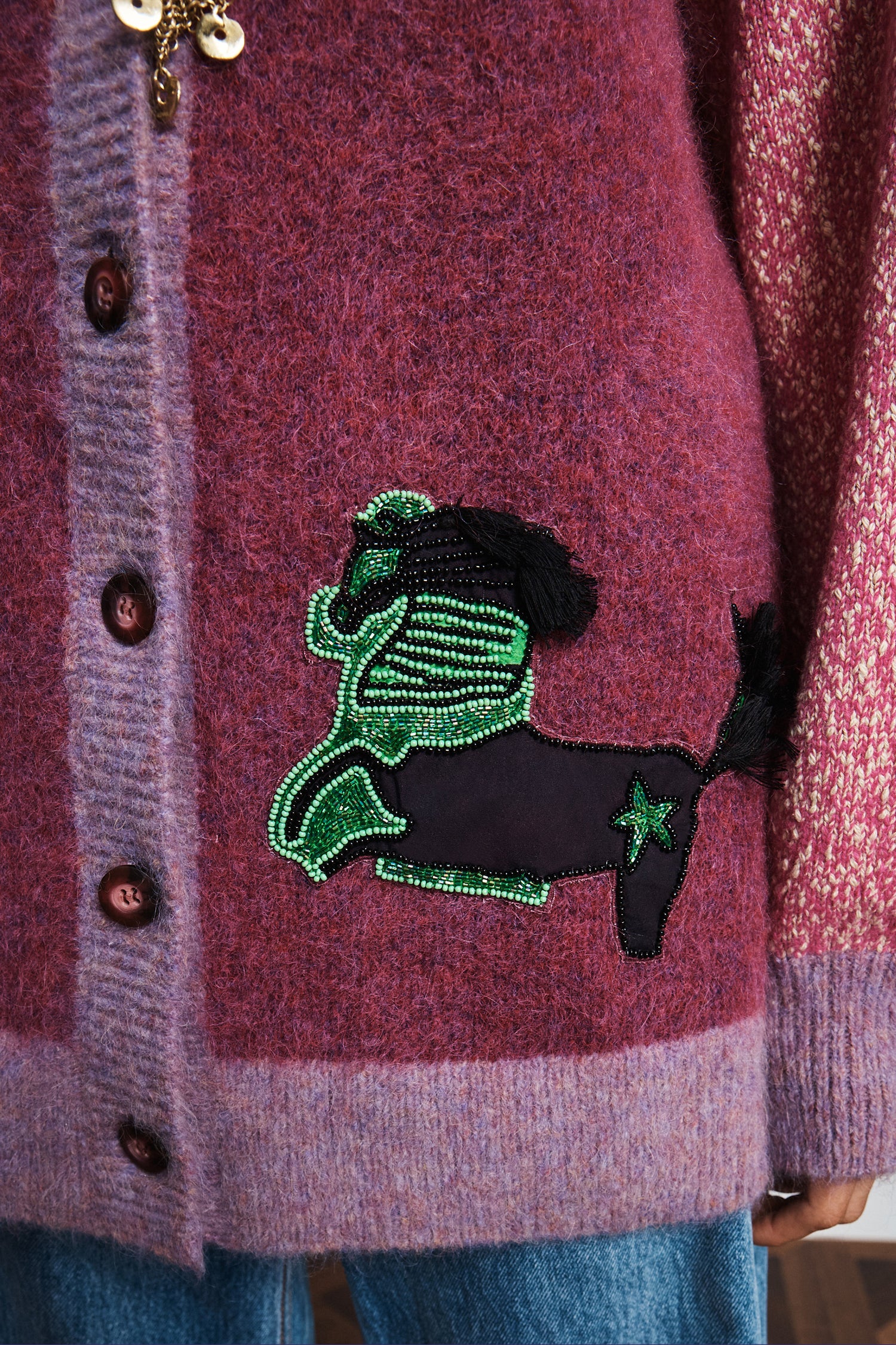 Close-up of a Alemais MLAK purple cardigan with a decorative fish patch.