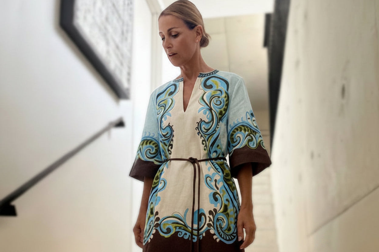 Woman in a alemais patterned dress standing on a staircase