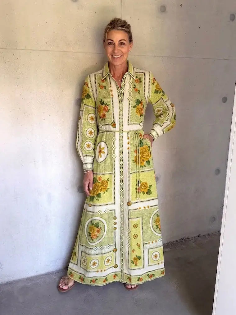 Alemais Dixi Shirt Dress worn by Woman,  long, patterned dress standing against a plain wall.