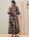 Alemais Jasper Shirtdress Woman wearing a floral dress standing in front of striped curtains