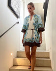 Woman in a patterned dress standing on a staircase