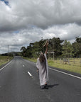 Person in a long estilo emporio maxi dress standing on a road with a cloudy sky