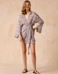 Woman wearing Estilo Emporio Leone Linen Dress a striped kimono-style garment on a beige background