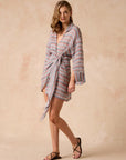 Woman wearing Estilo Emporio Leone Linen Dress a striped robe against a beige background