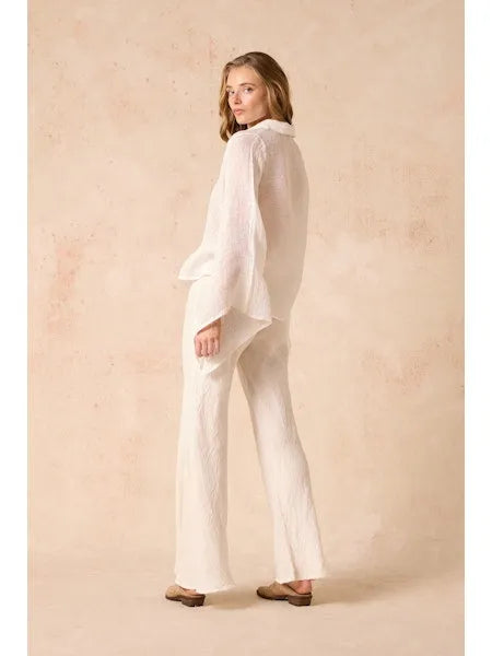 Woman wearing Estilo Emporio linen  a white outfit against a beige background