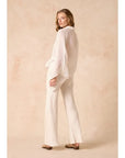 Woman wearing Estilo Emporio linen  a white outfit against a beige background