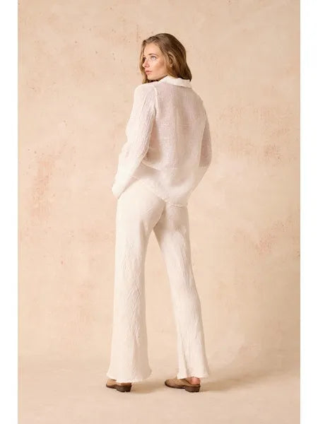 Woman Estilo Emporio linen wearing a white outfit against a beige background