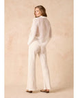 Woman Estilo Emporio linen wearing a white outfit against a beige background