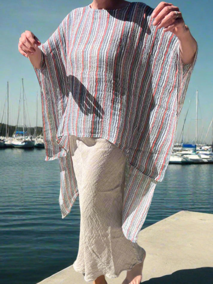 Person holding a striped garment outdoors on a sunny day