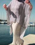 Person holding a striped garment outdoors on a sunny day