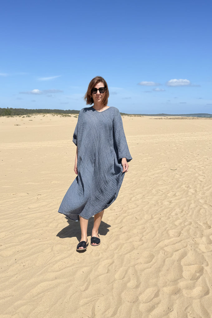 womon walking on sand in la bottega di brunella fausta dress