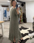 Woman taking a mirror selfie wearing a long green la bottega di brunella linen dress in a room with decor elements.