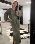 Woman taking a mirror selfie wearing a green  la bottega di brunella linen dress in a room with a cowhide rug.