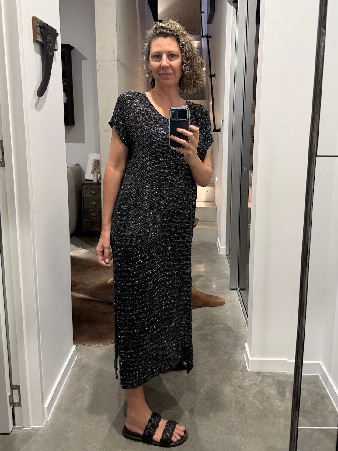 Woman taking a mirror selfie wearing a la bottega di brunella linen dress made in italy in a room.