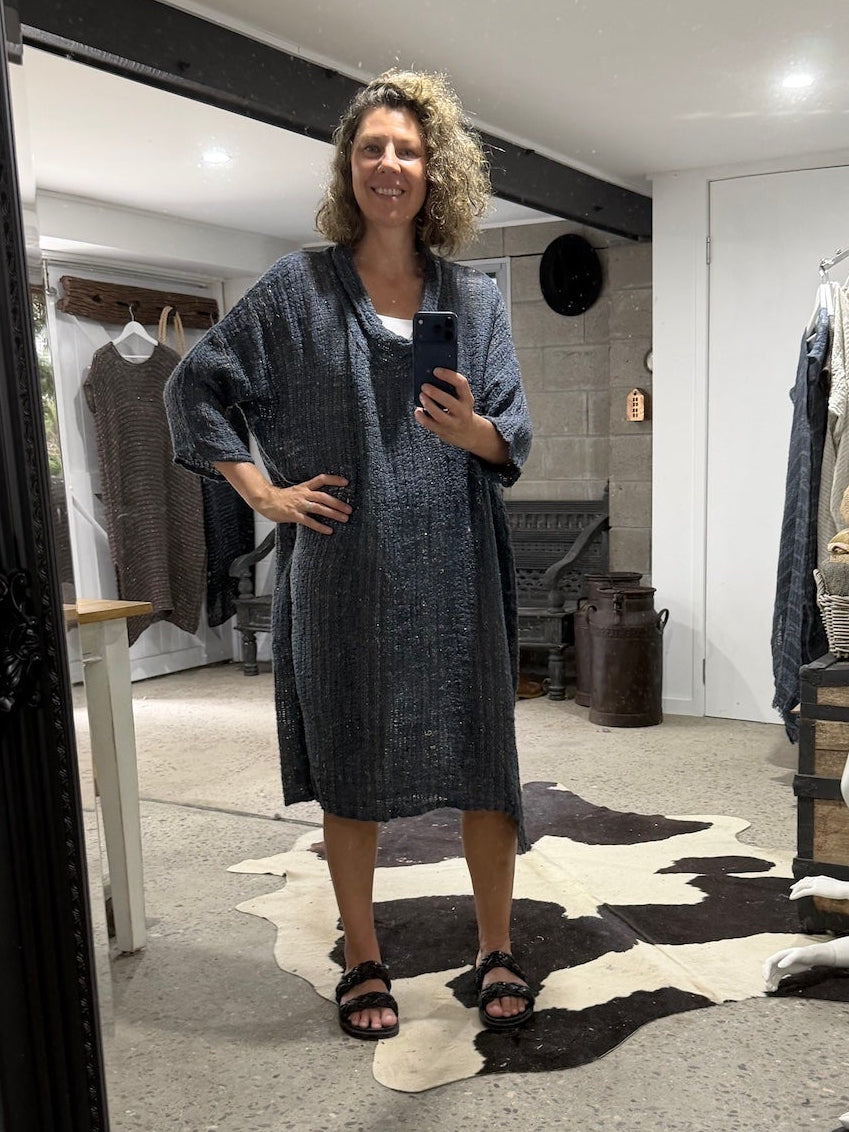 Woman taking a mirror selfie wearing a la bottega di brunella linen dress in a  room with a large mirror.