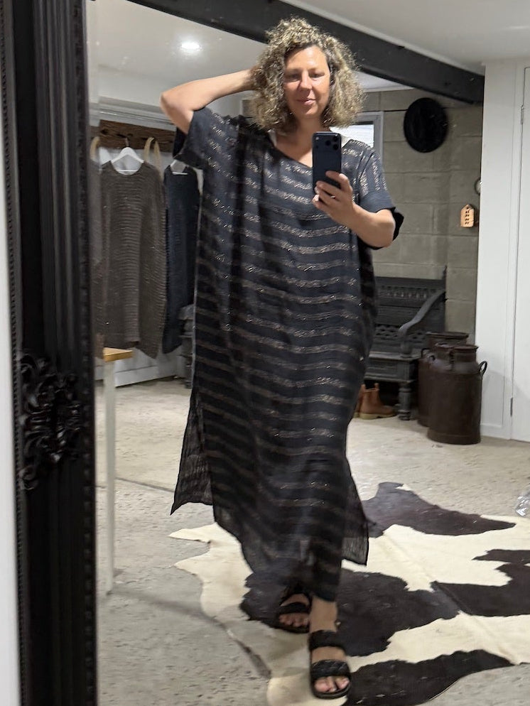 Person wearing a long striped  la bottega di brunealla navy linen dress in a room with a mirror.