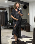 Person taking a mirror selfie wearing a la bottega di Brunella navy linen dress in a room with a large black-framed mirror.