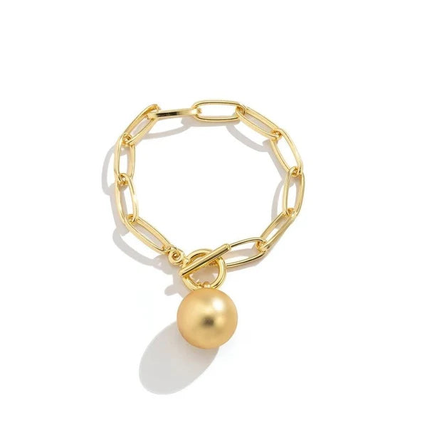 Orna Curio Golden Years Gold Plated Bracelet - LUXAMORE -Bracelets-Gold Plated Bracelet The perfect bracelet Introducing the 'Golden Years' Bracelet, a heartfelt homage to the legendary David Bowie. Crafted in stunning gold-plated alloy, this bracelet stands as a statement piece on its own or offers the canvas for your creativity with the addition of your favorite charms. It showcases a captivating hanging ball and a bold large link chain. Materials: Gold Plated Alloy Measurements: 18cm